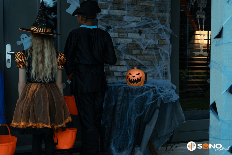 Entrée décorée pour Halloween avec enfants déguisés et déco citrouille 